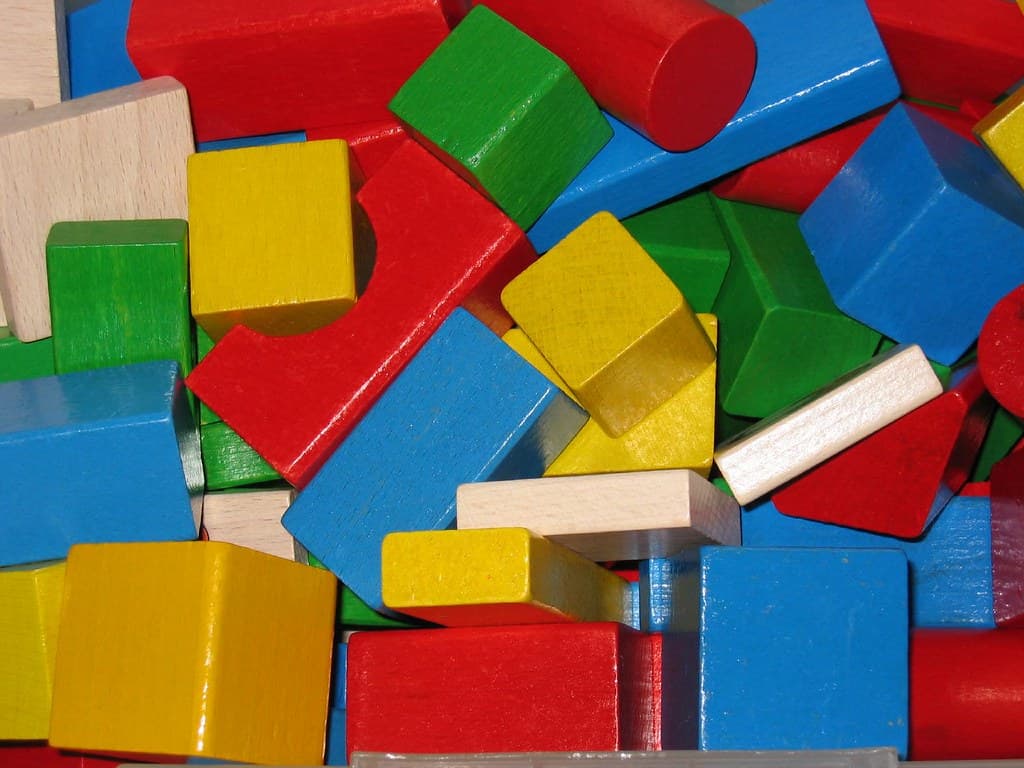 Blocos de montar coloridos, brinquedo comum em salas de terapia infantil.